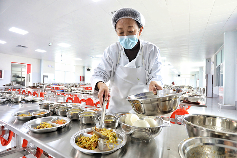 學(xué)校食堂工作人員正在準(zhǔn)備午餐。陳陽攝
