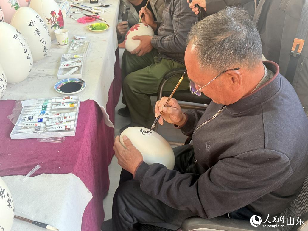 上冶鎮(zhèn)村民正在繪畫金蛋紋樣。 人民網(wǎng) 李子悅攝