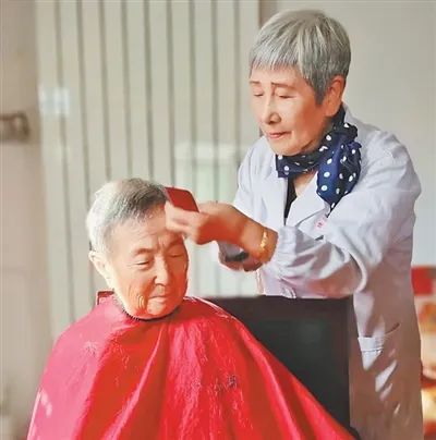 趙曉鳳在為居民義務(wù)理發(fā)。劉智峰攝